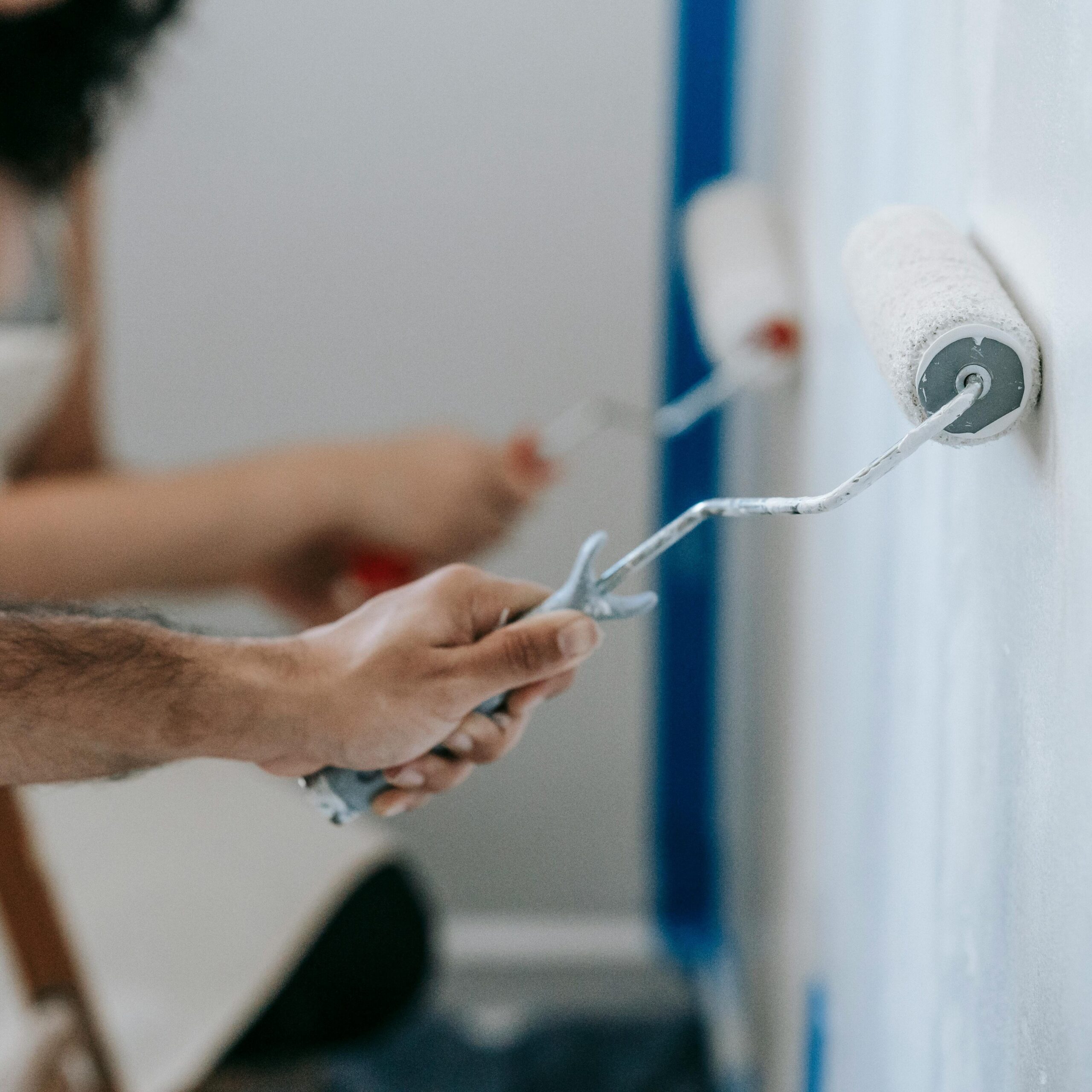 pexels photo 7218568 7218568 Couple painting a wall with rollers, perfect for home improvement and renovation themes.